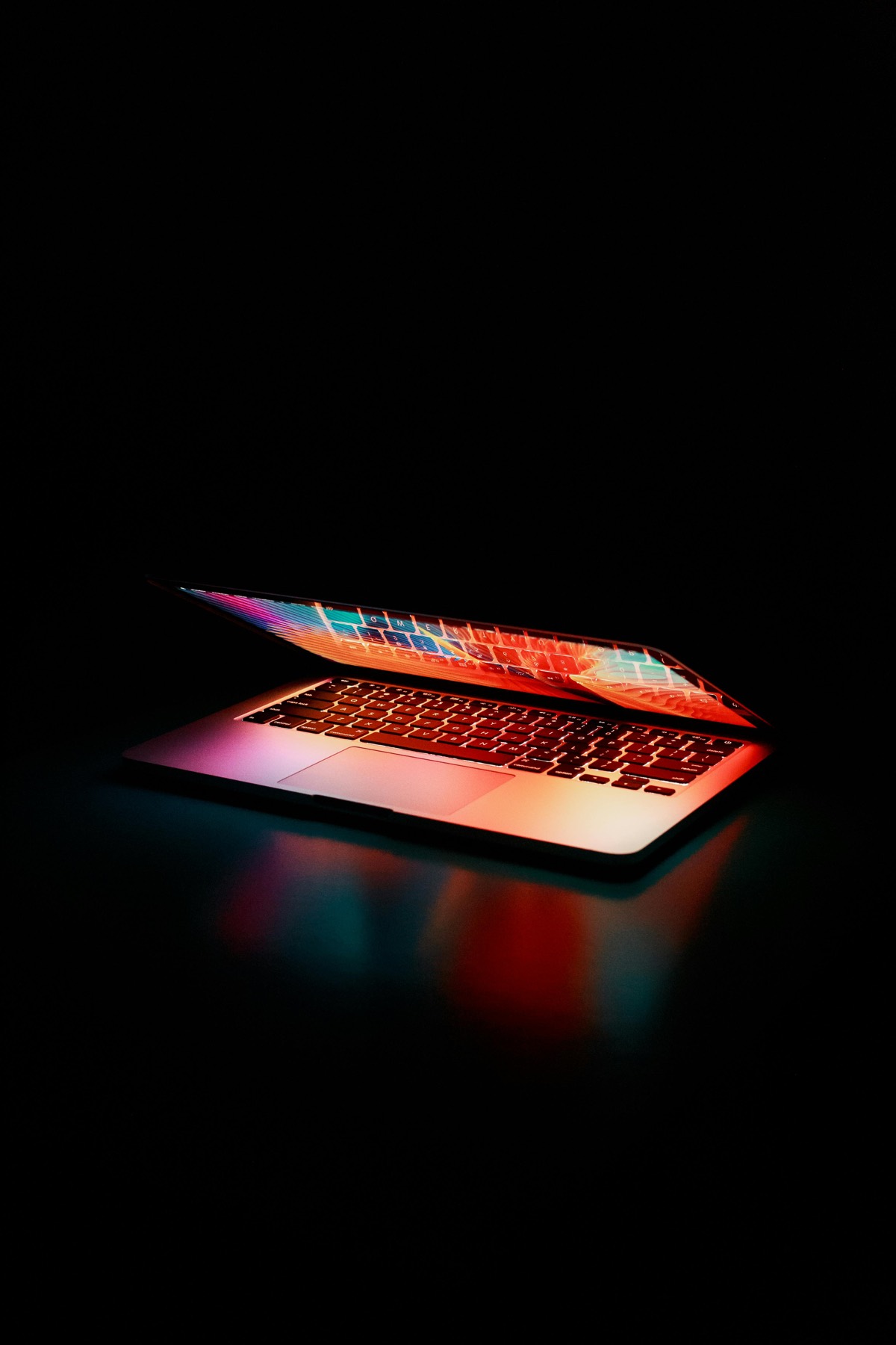 Laptop screen glowing with code in a dark room