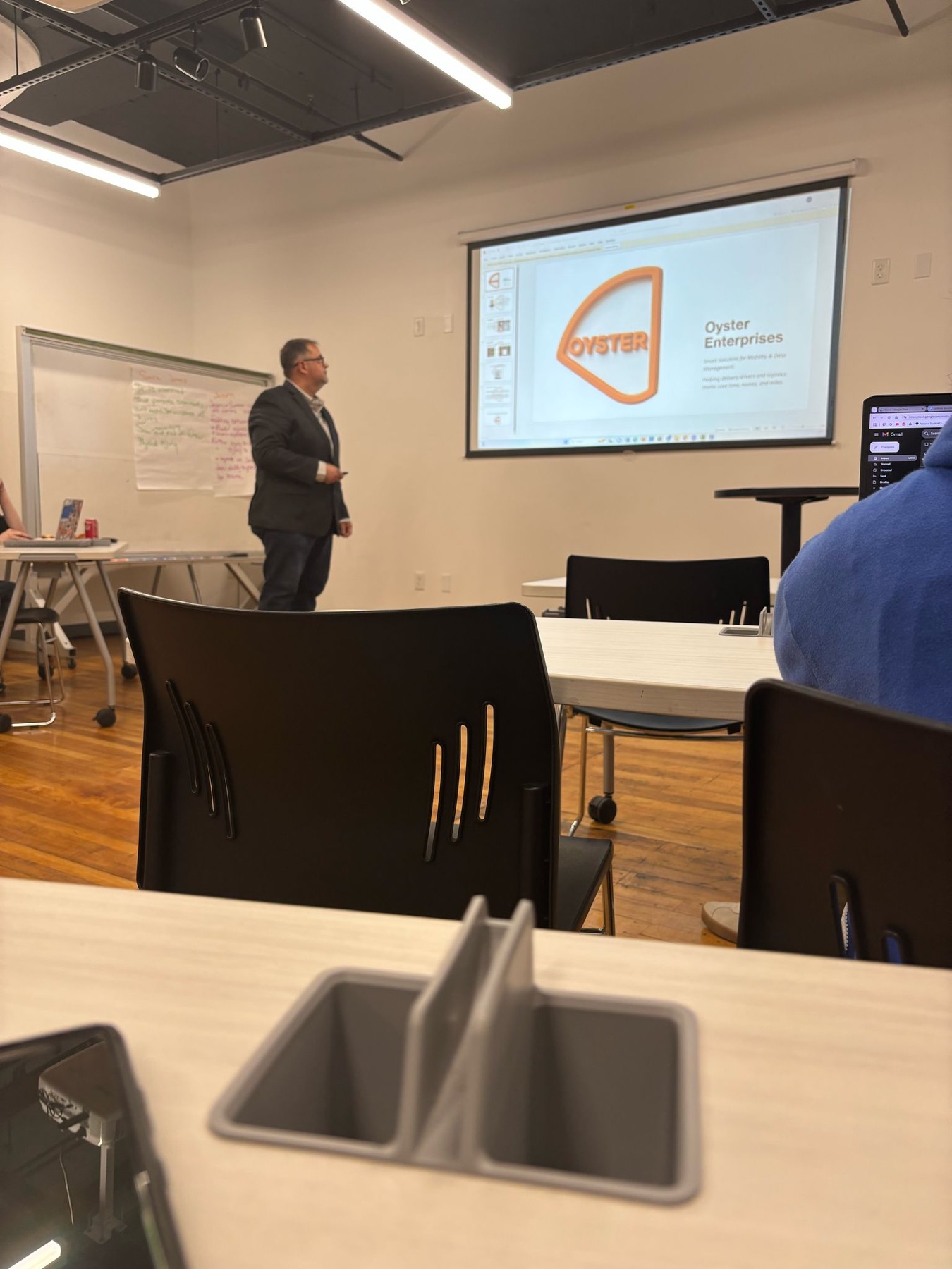 Elir Melo presenting Oyster Enterprises on a projector screen during a Startup Worcester workshop