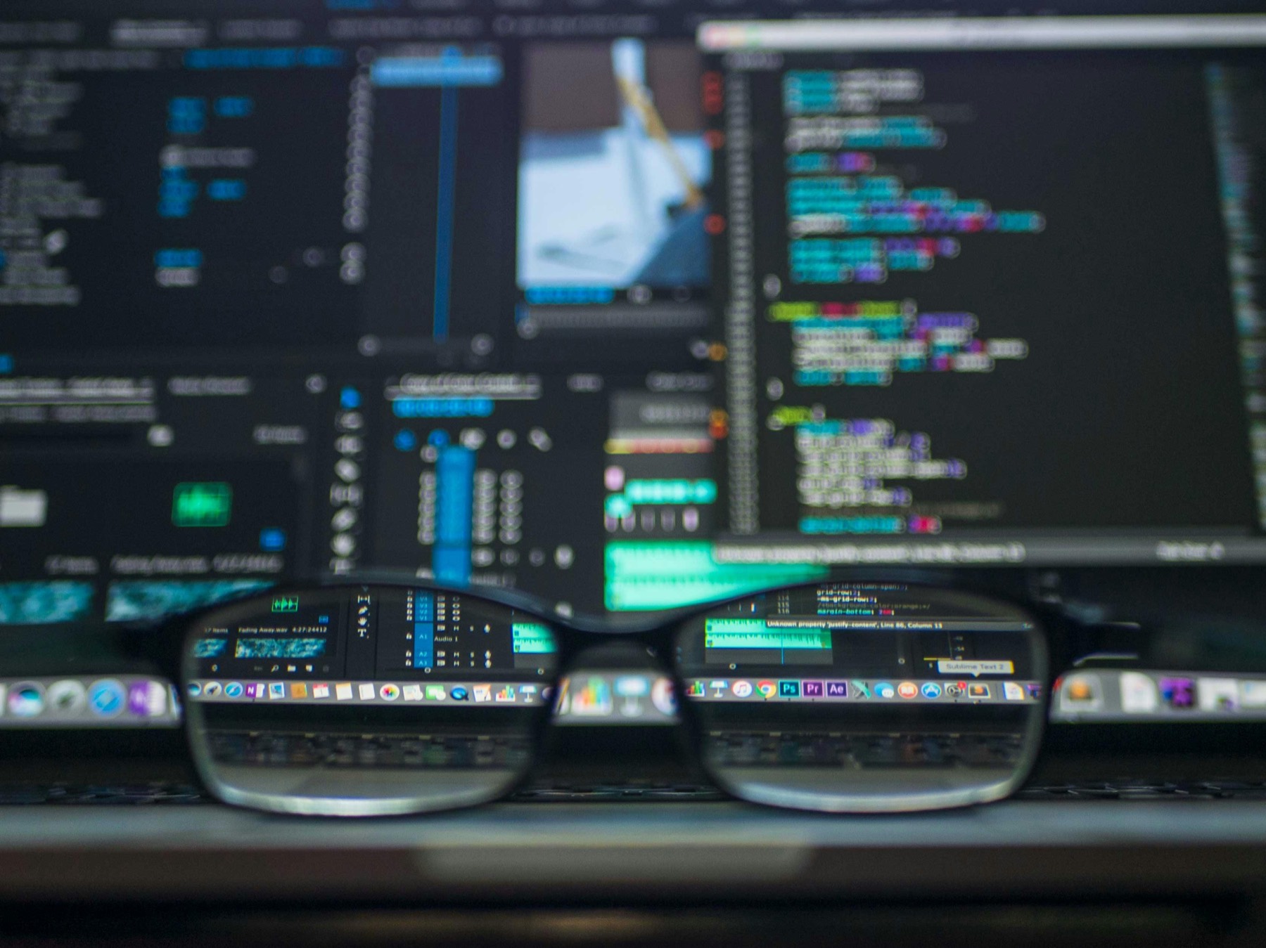 Close-up of a code editor and audio timeline software on a developer's screen